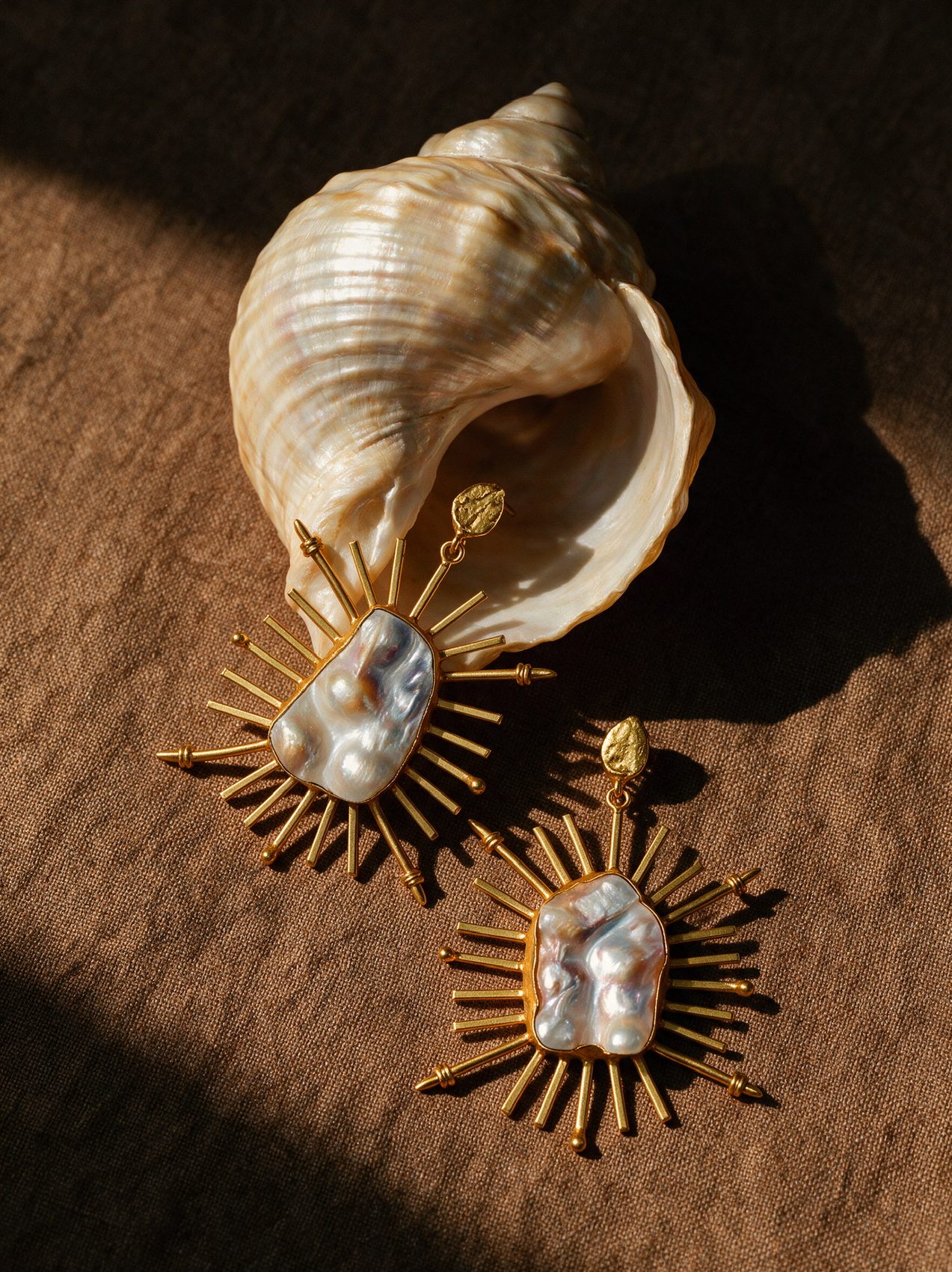 Three pearl earrings on rust-coloured silk
