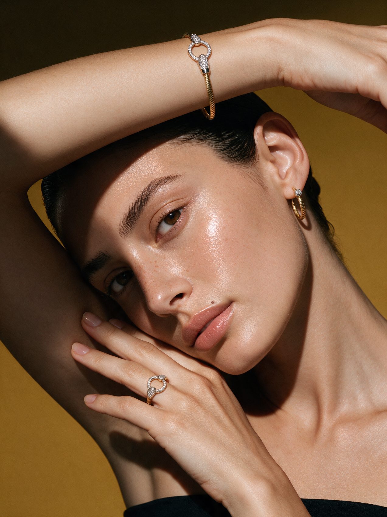 Close portrait with pavé ring, cuff and bezel hoop on ochre